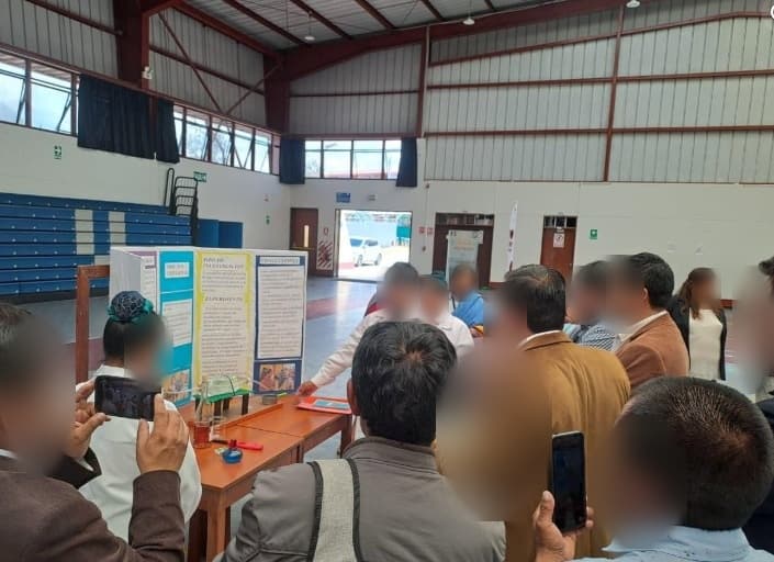 Estudiantes exponen su proyecto ante el jurado y las familias, que toman fotos con sus celulares