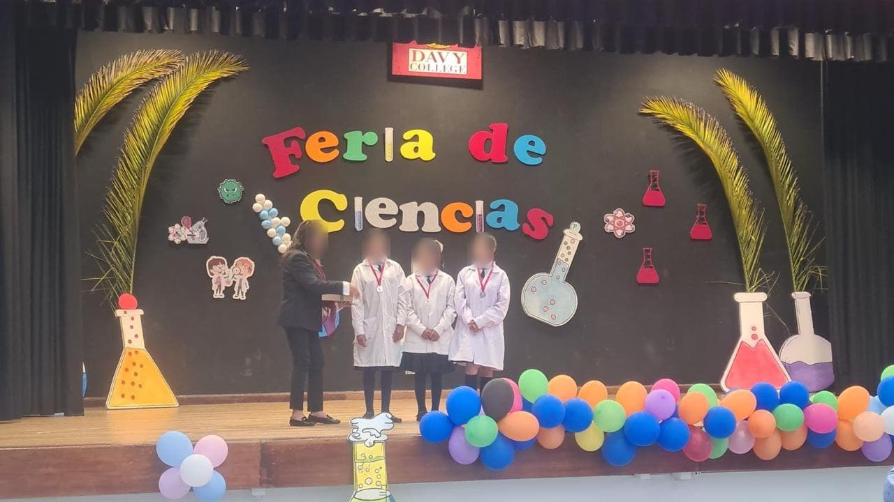 Estudiantes con mandil en el escenario durante la premiación