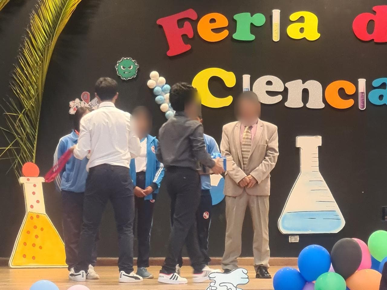 Docentes entregan reconocimientos a estudiantes en el escenario